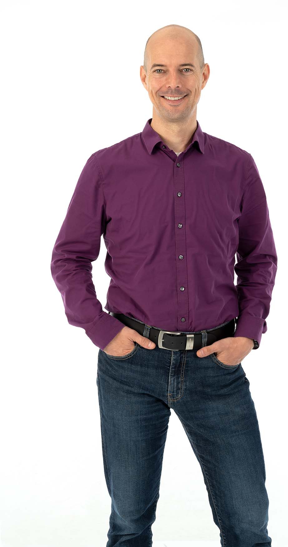 Sebastian Kremser stehend in Jeans und dunkel-violettem Hemd